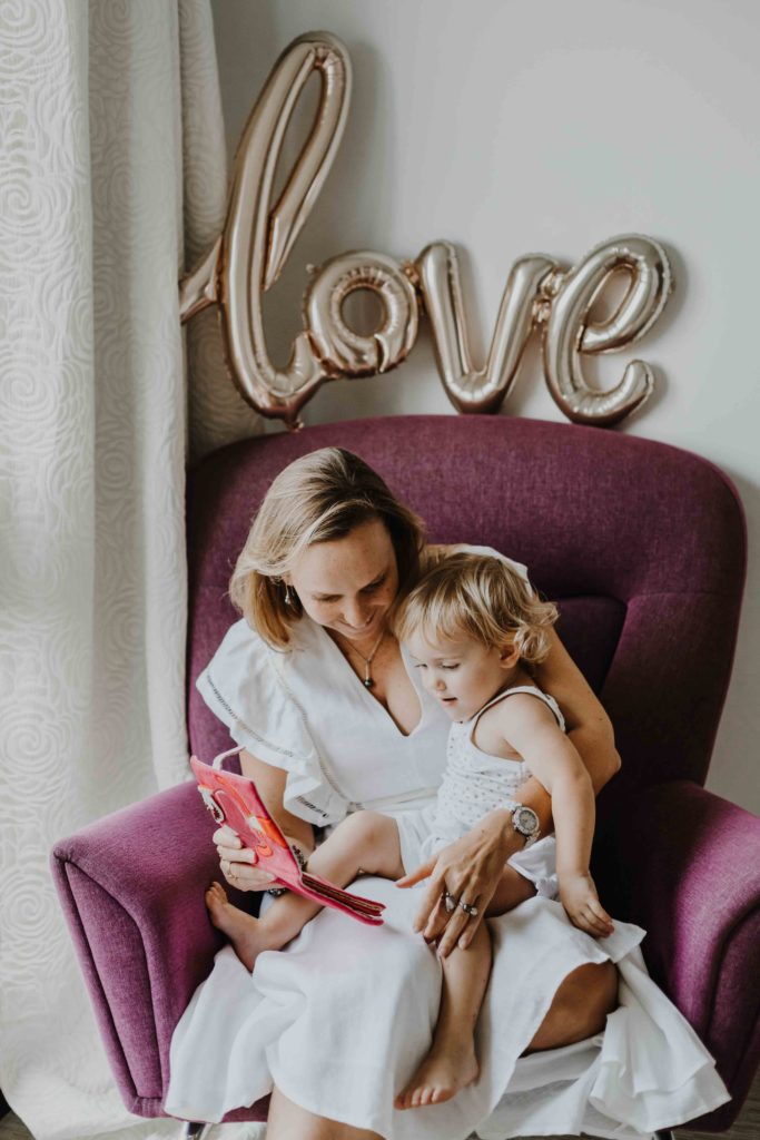 photographe famille lifestyle à domicile, immortaliser des moments de complicité et de douceur dans votre environnement quotidien. Maman et bébé lisent un livre à Mulhouse