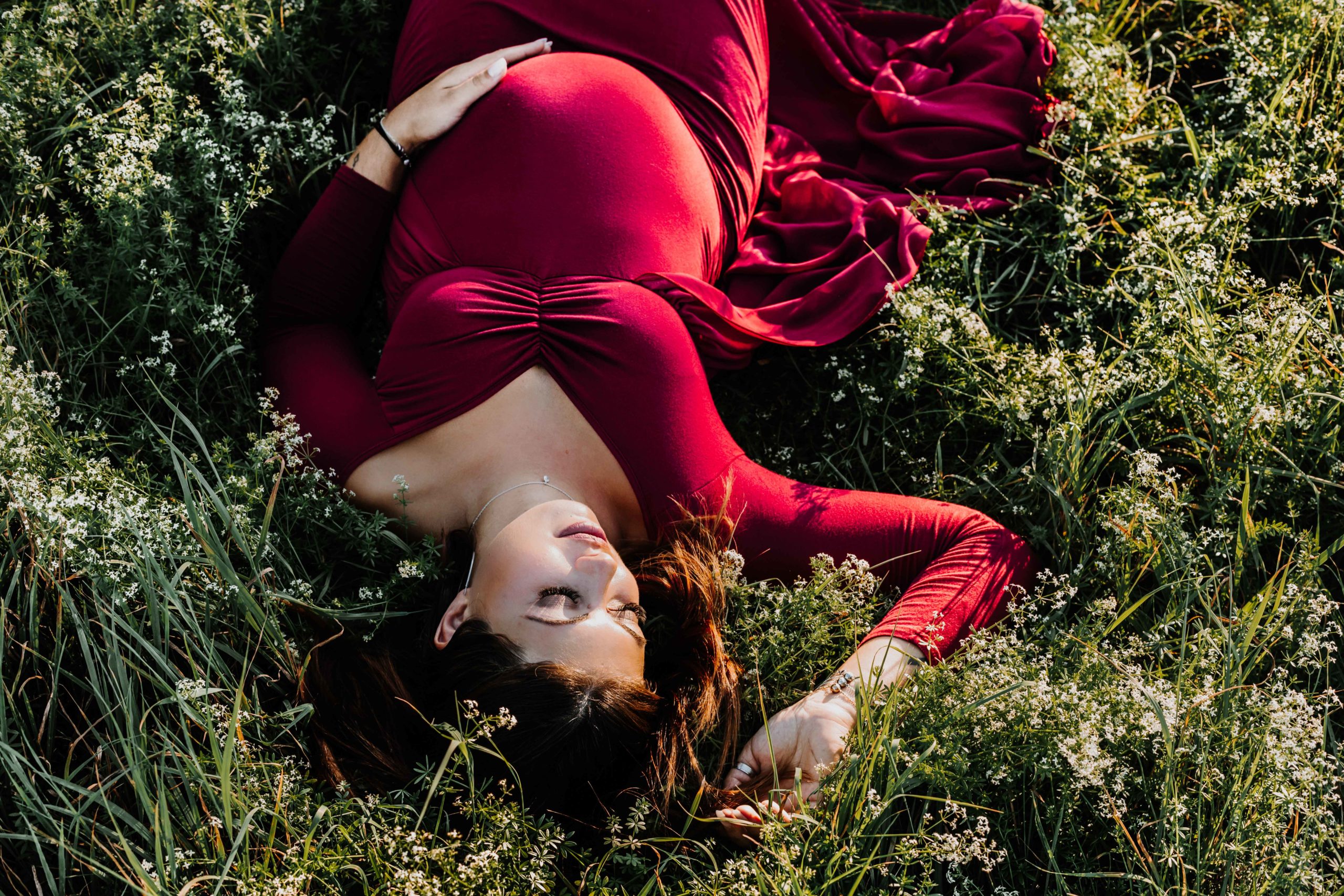 femme enceinte allongée dans l'herbe et les fleurs