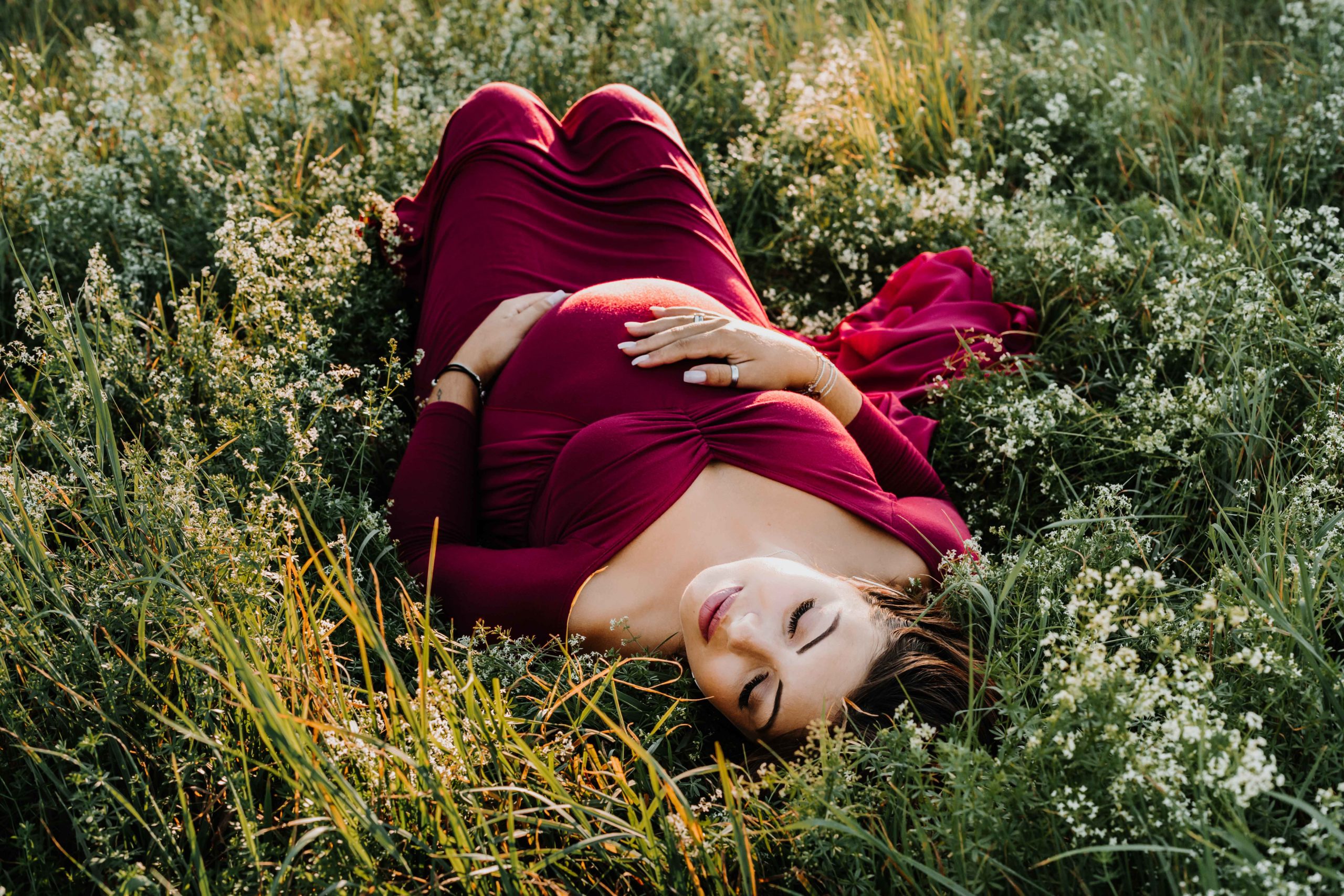femme enceinte allongée dans les fleurs et l'herbe, endormie