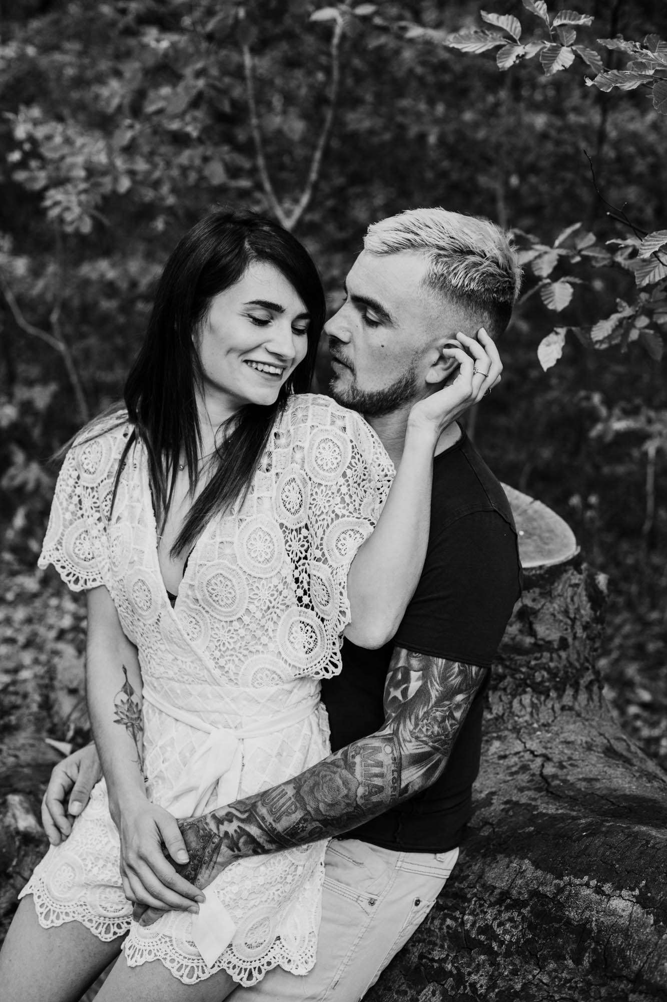 photo noir et blanc d'un couple, les deux amoureux sont l'un contre l'autre dans la forêt