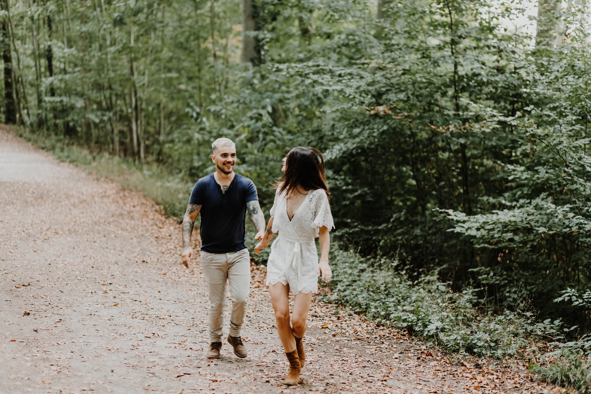un couple marche dans la forêt en riant