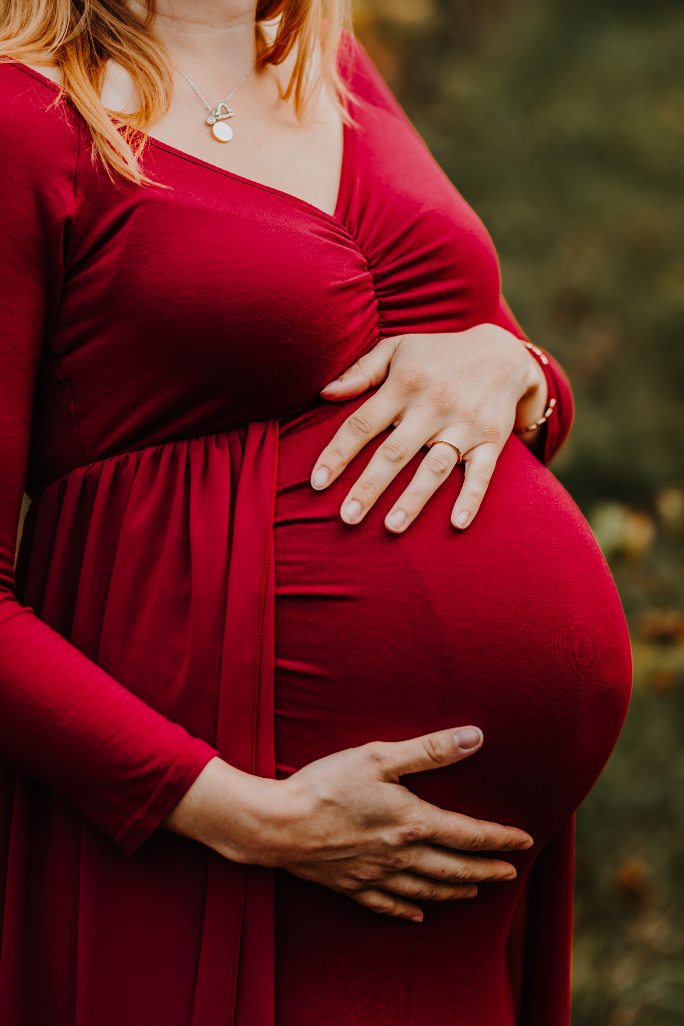 détail du ventre rond d'une femme enceinte dans une robe rouge