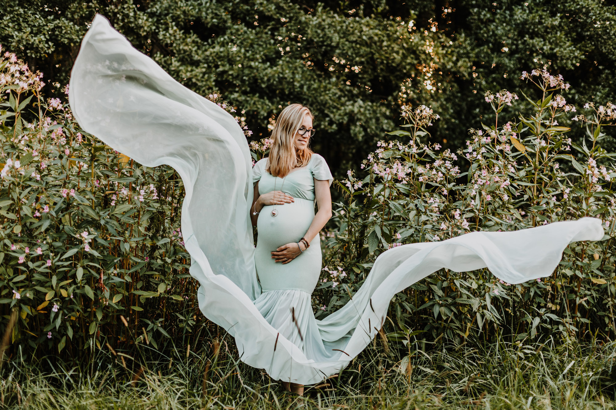 femme enceinte dans un ongle robe dans un champs de fleurs