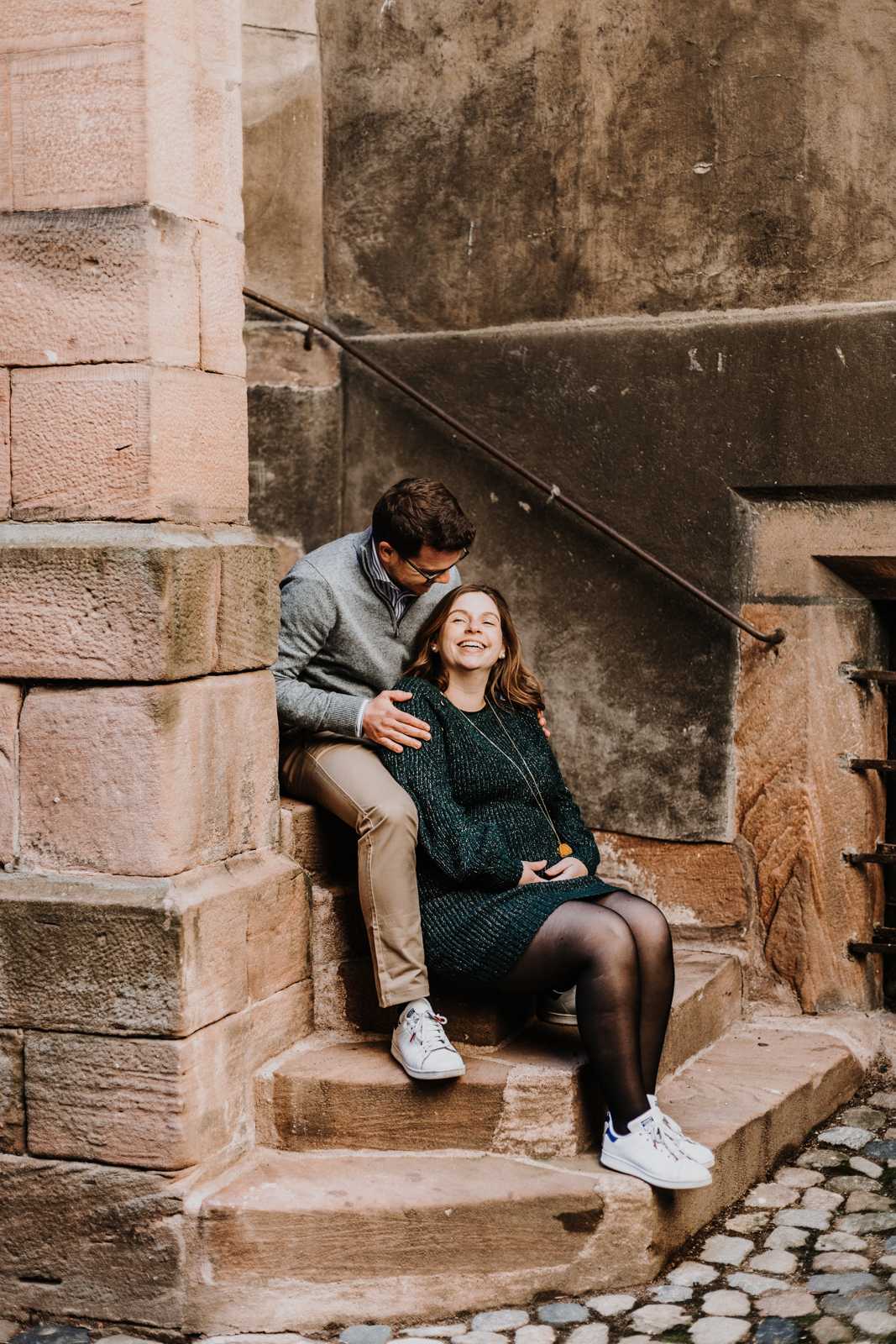 un couple assis sur des escaliers en pierre