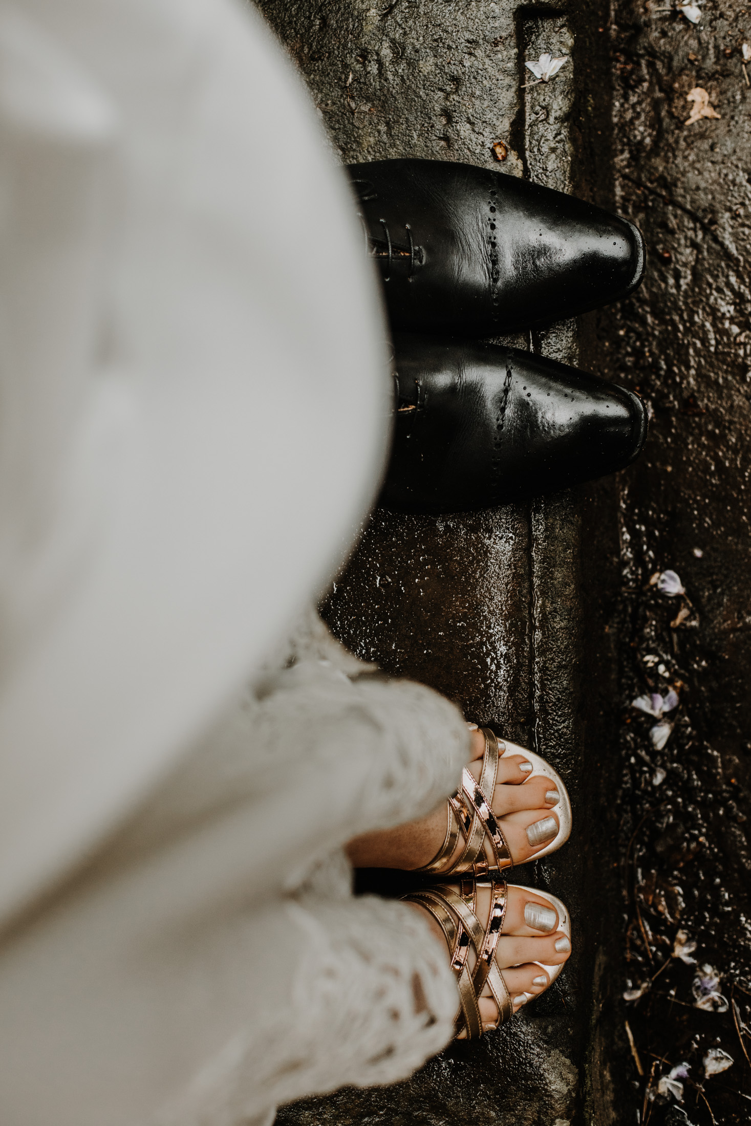 détail des chaussures des mariés sur le sol mouillé par la pluie