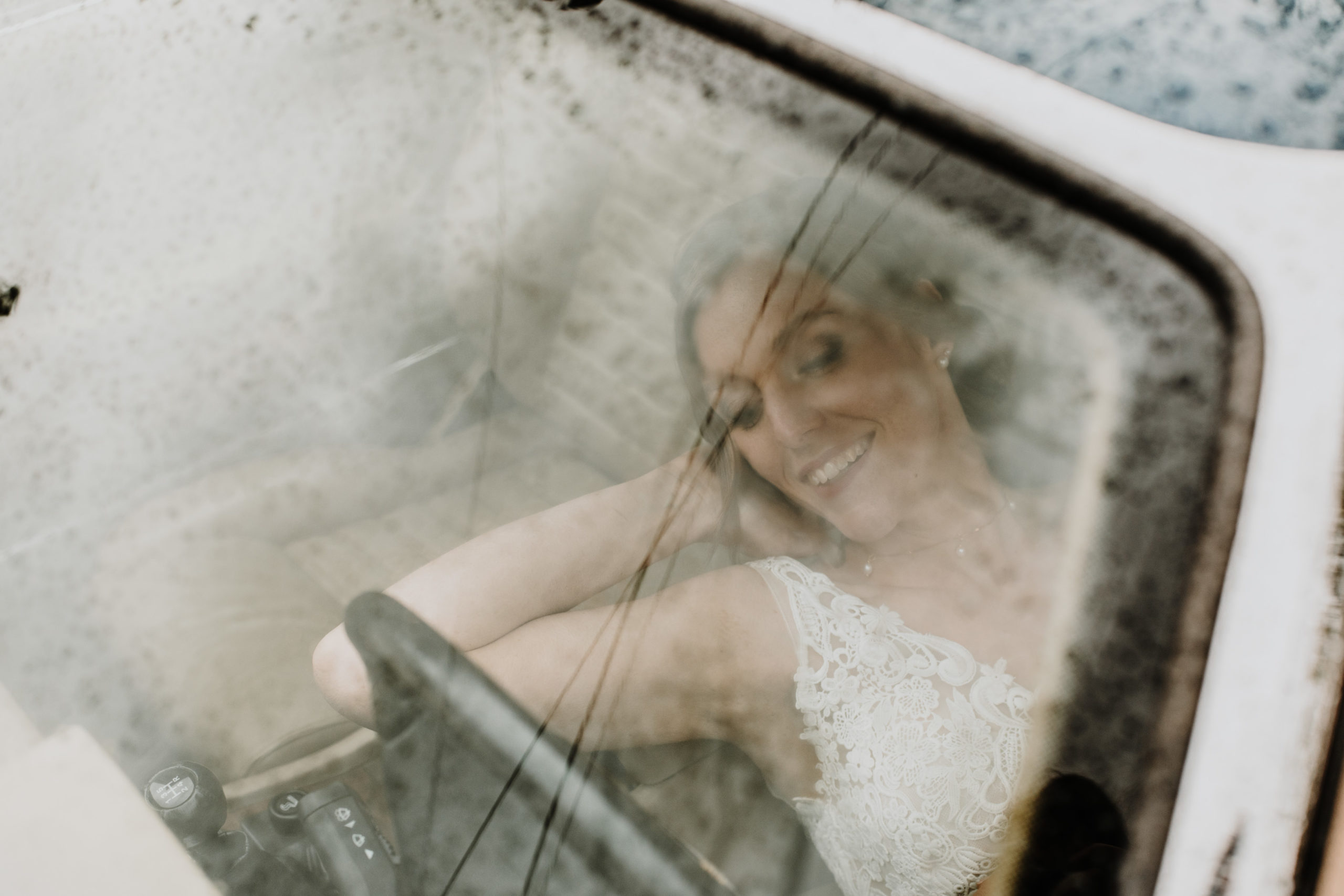 la mariée allongée dans la voiture ancienne, ses jambes dépassent de la fenêtre