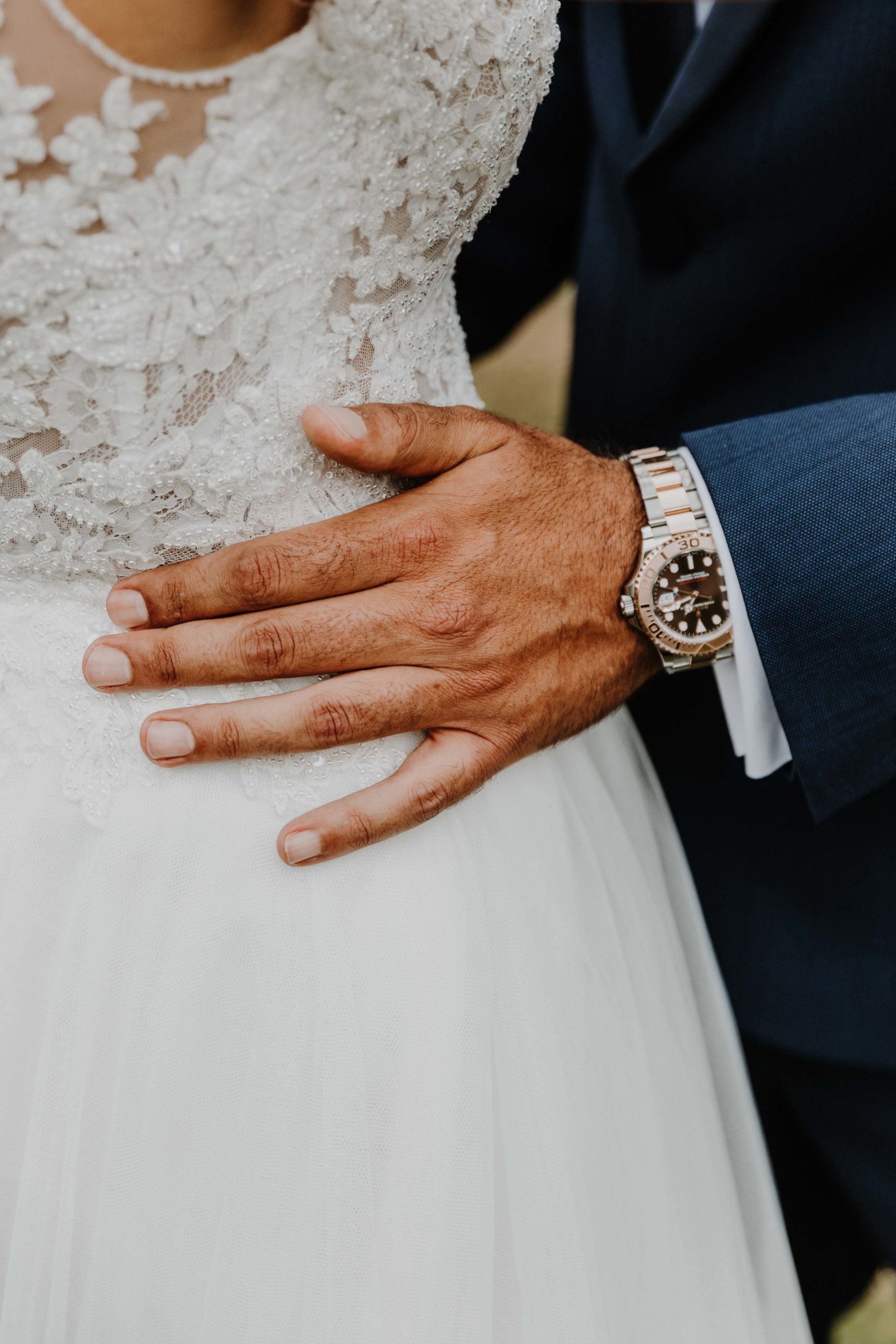 détail de la main du marié sur la taille de la mariée
