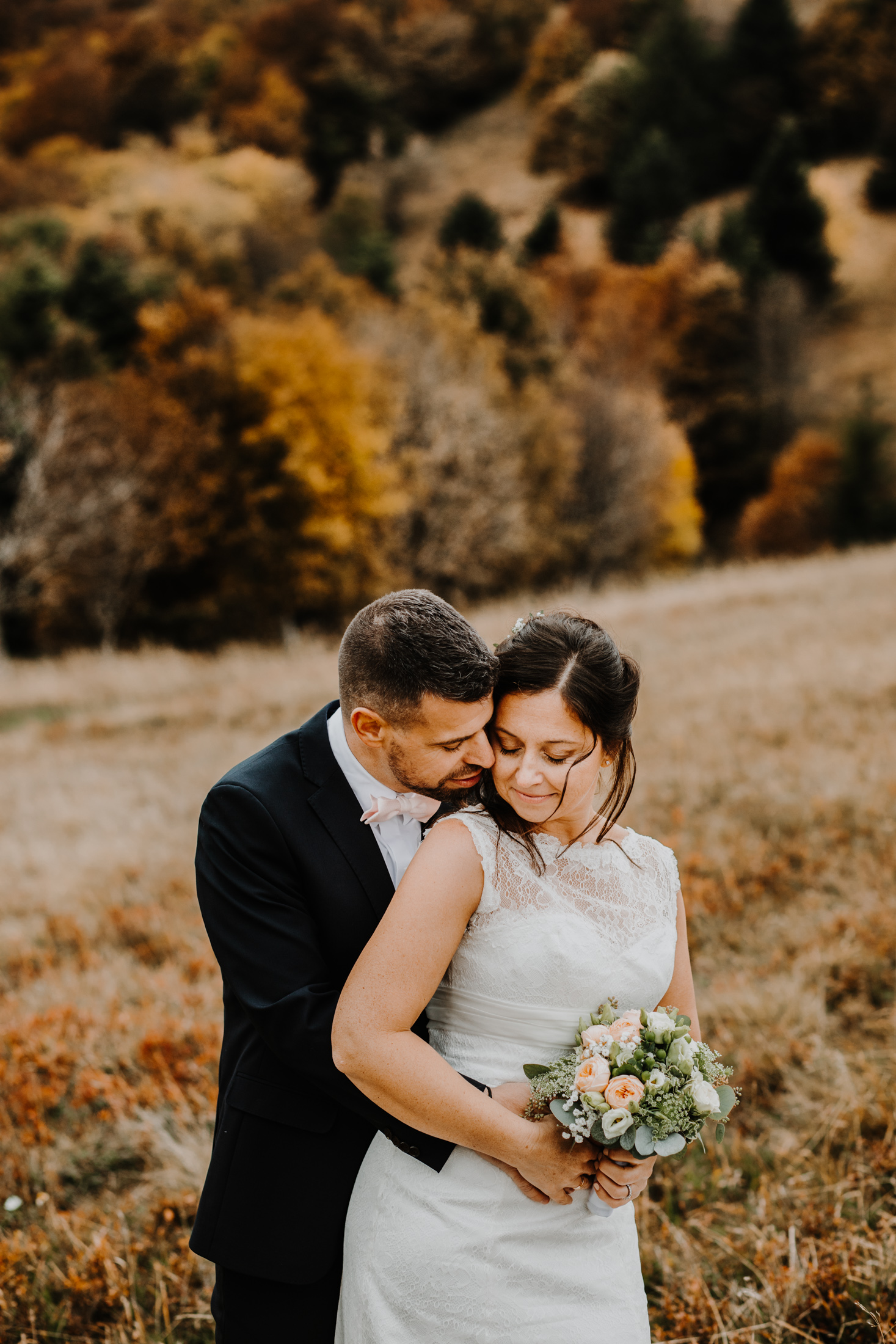 couple de mariés enlacés dans un décor de montagne en automne
