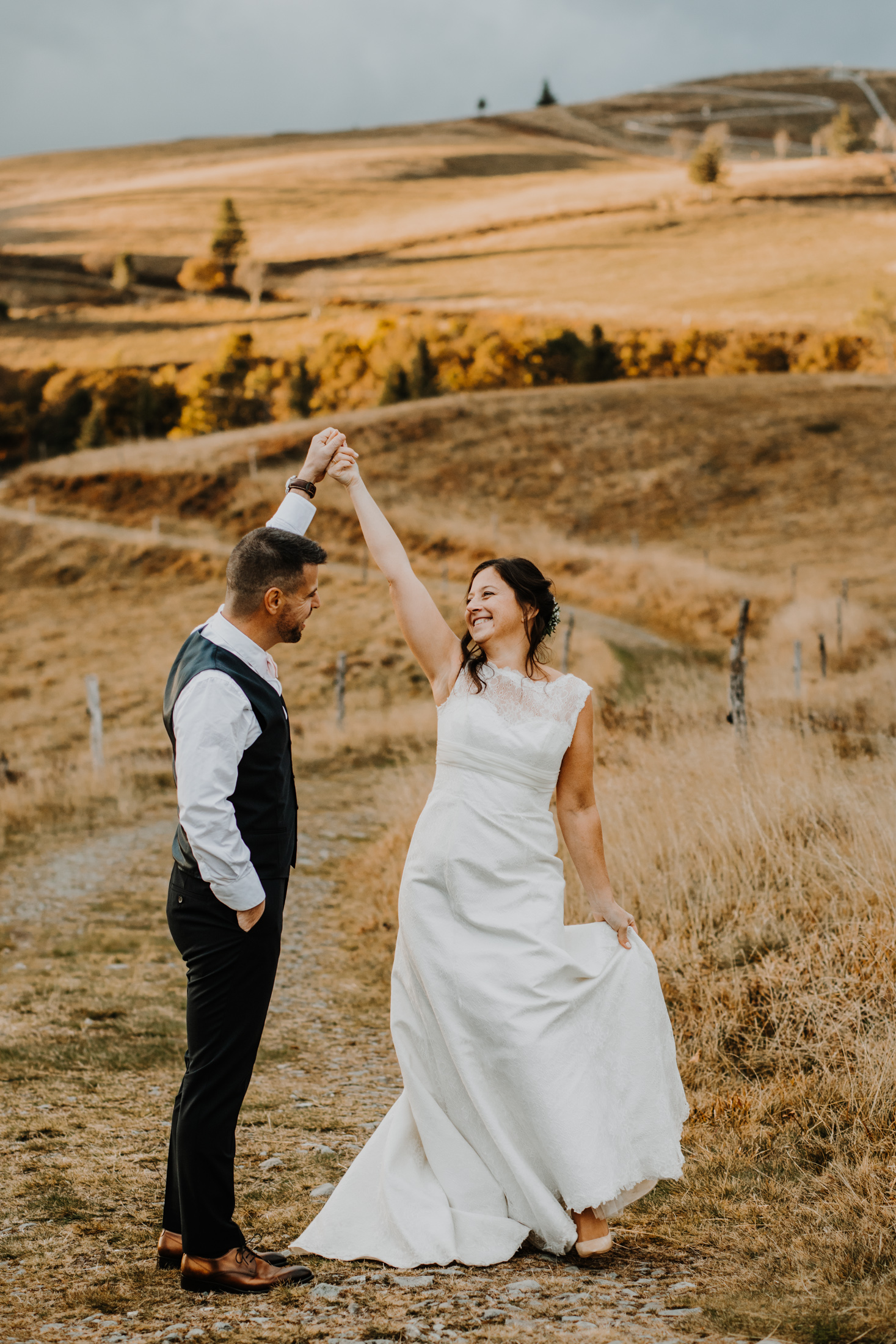 couple de mariés danse dans un décor de montagne