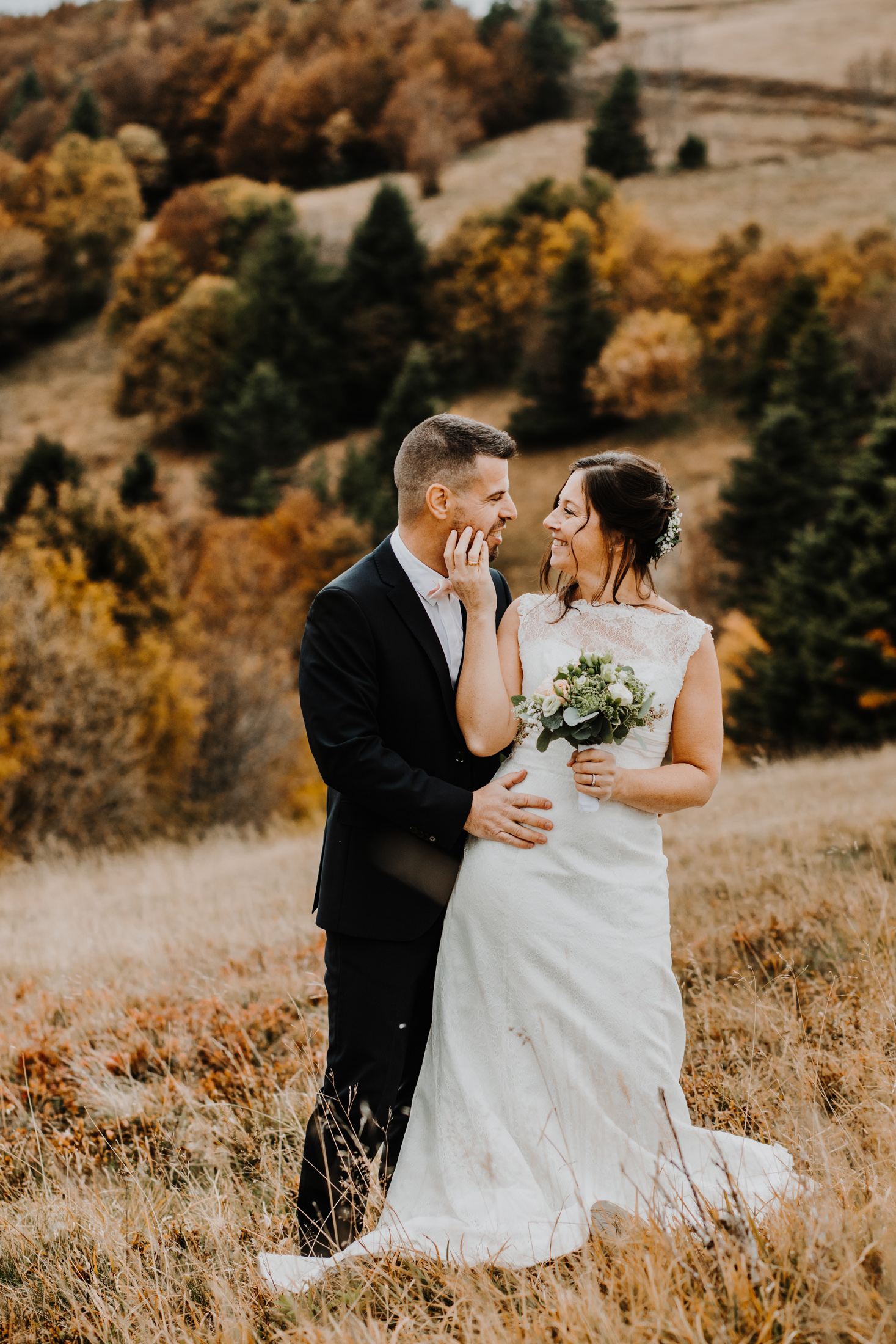 couple de mariés enlacés dans un décor de montagne en automne