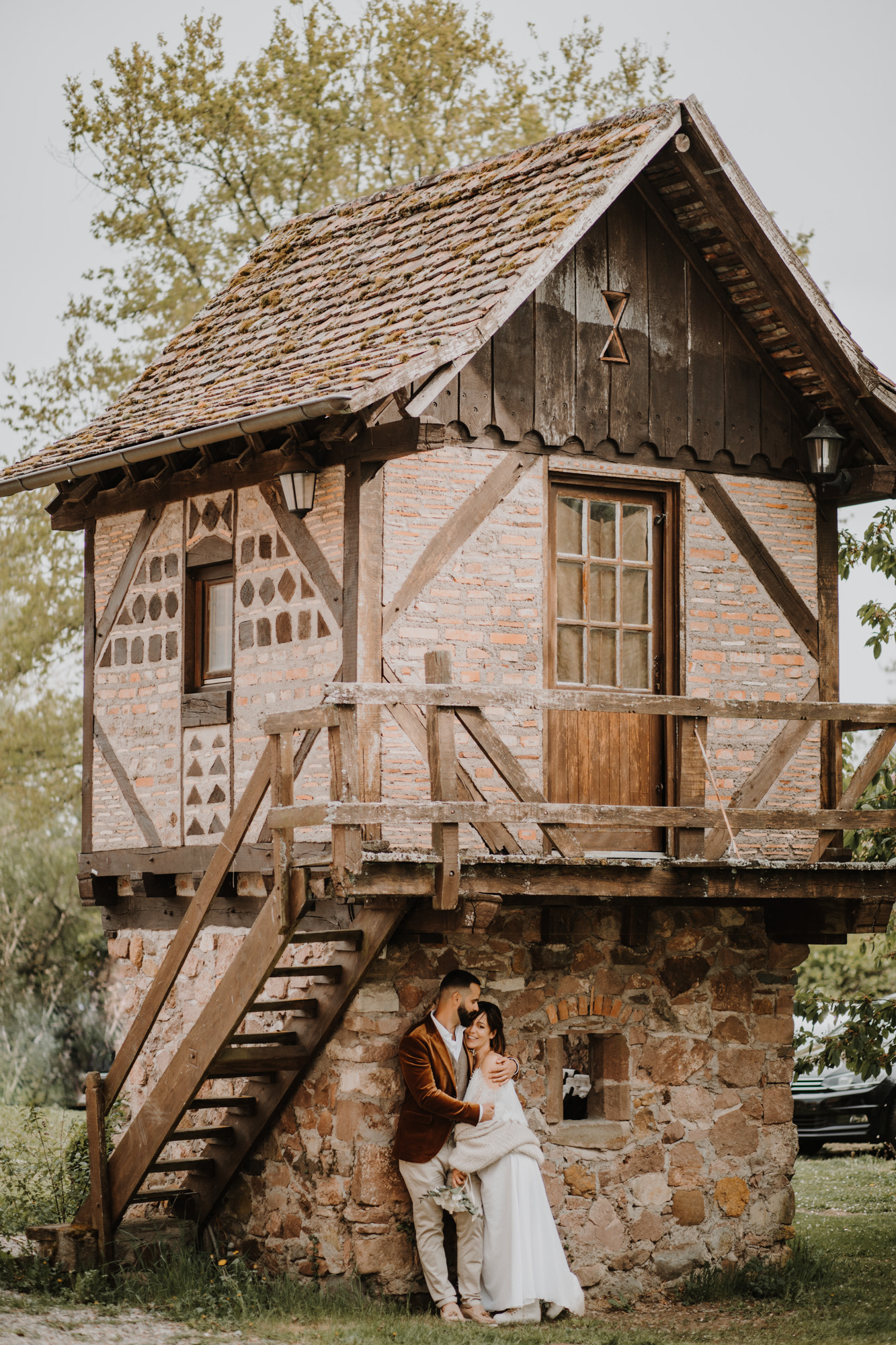 les mariés enlacés devant un bâtiment alsacien ancien domaine saint loup