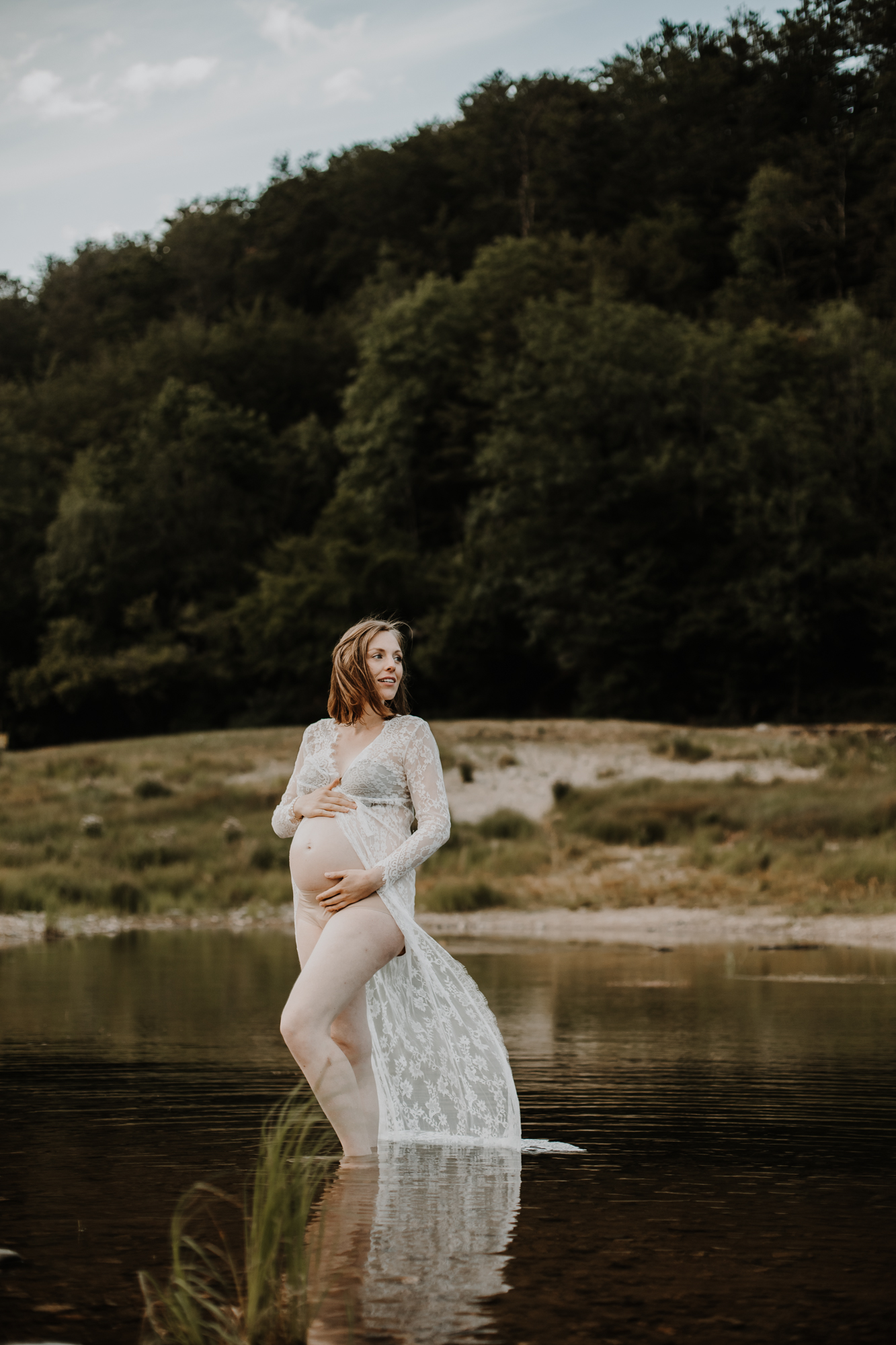 femme enceinte les pieds dans l'eau du lac