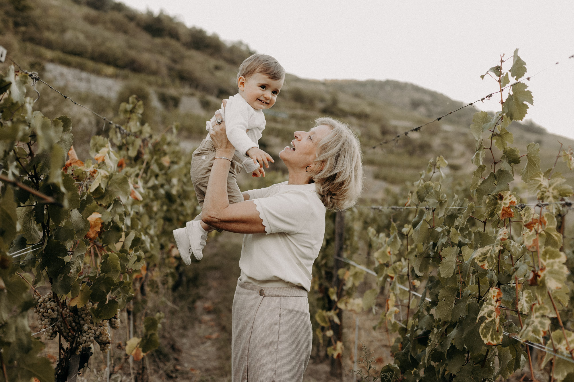 une grand-mère porte ans ses bras son petit-fils