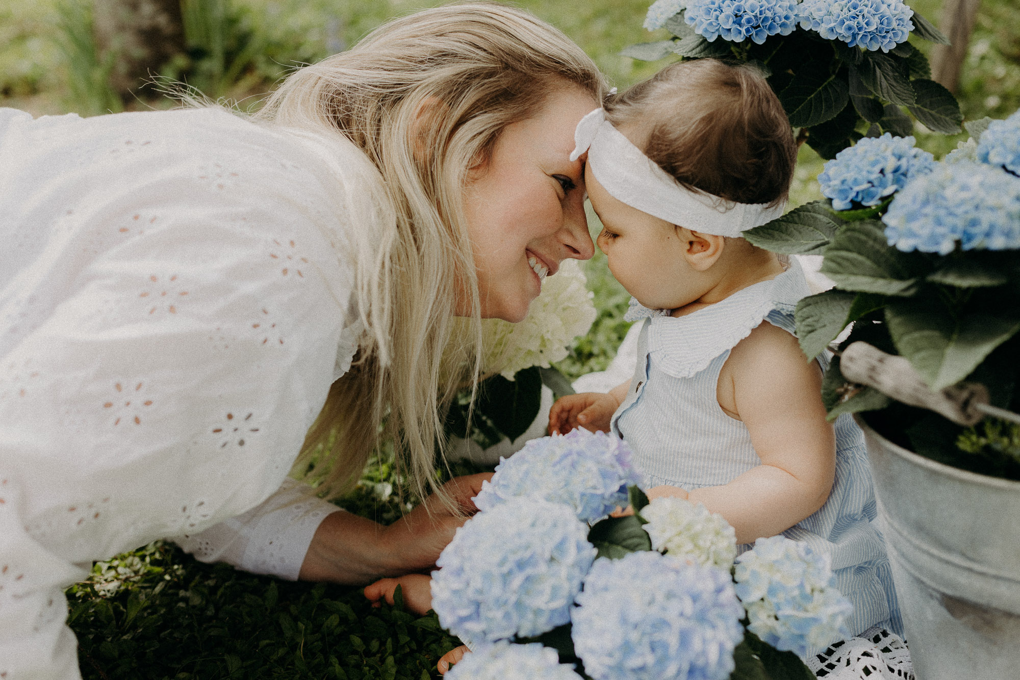 une petite fille et ses parents marchent main dans la main dans un vignoble en alsace 