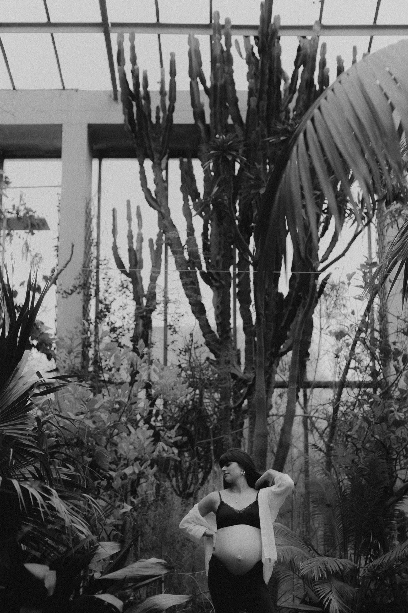 couple et femme enceinte s'embrassent dans une serre tropicale