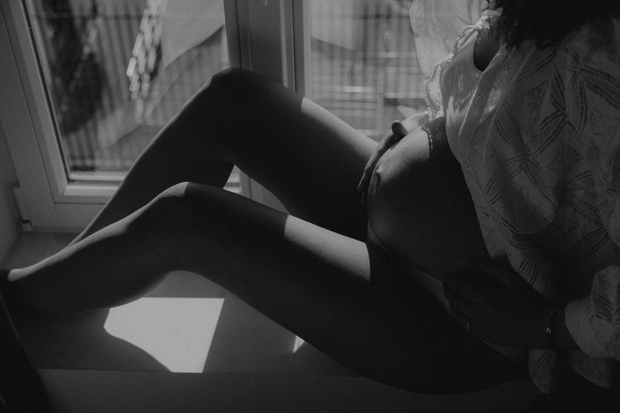 silhouette d'un ventre de femme enceinte au bord de la mer au coucher du soleil