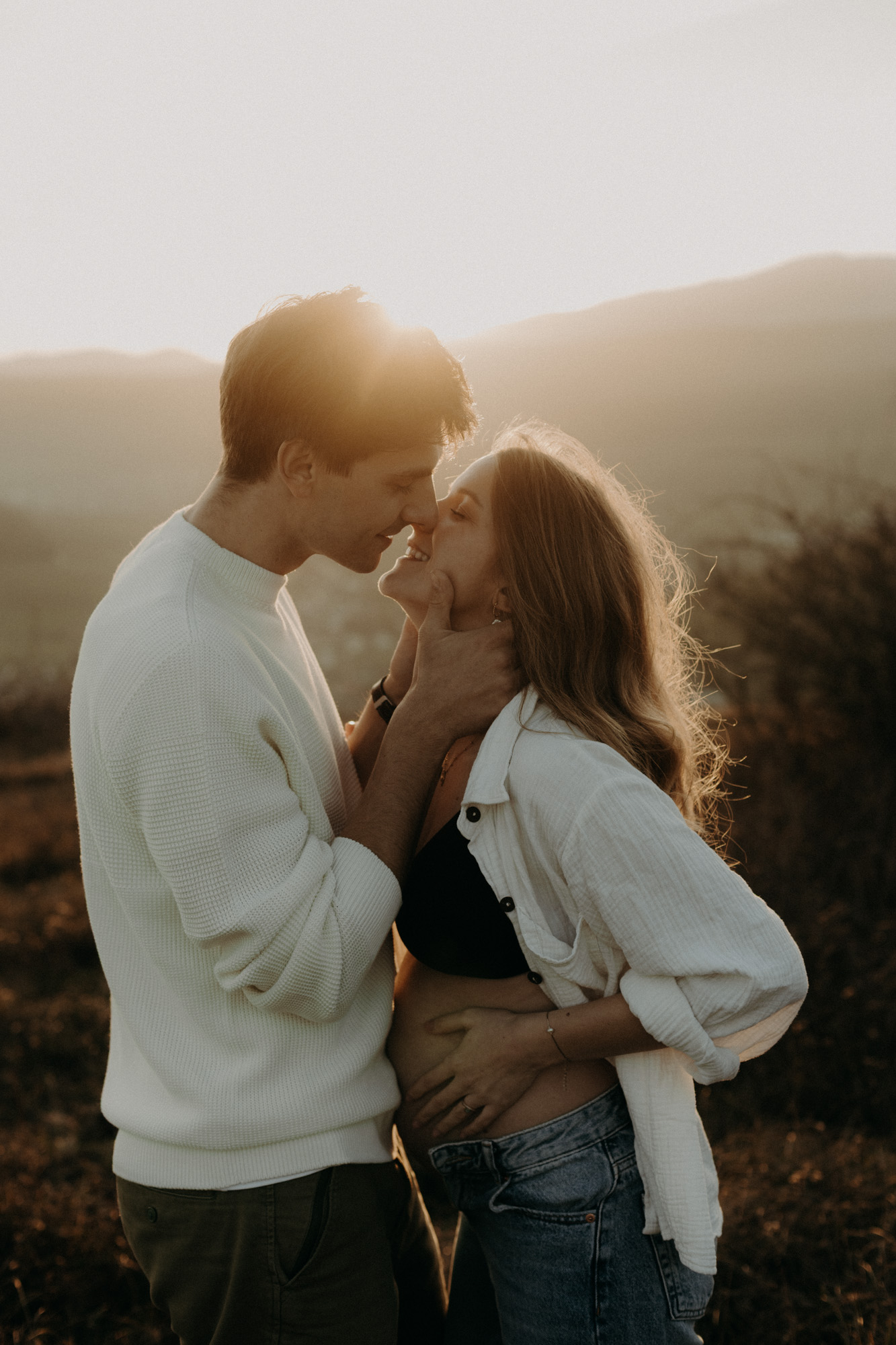 silhouette d'un ventre de femme enceinte au bord de la mer au coucher du soleil