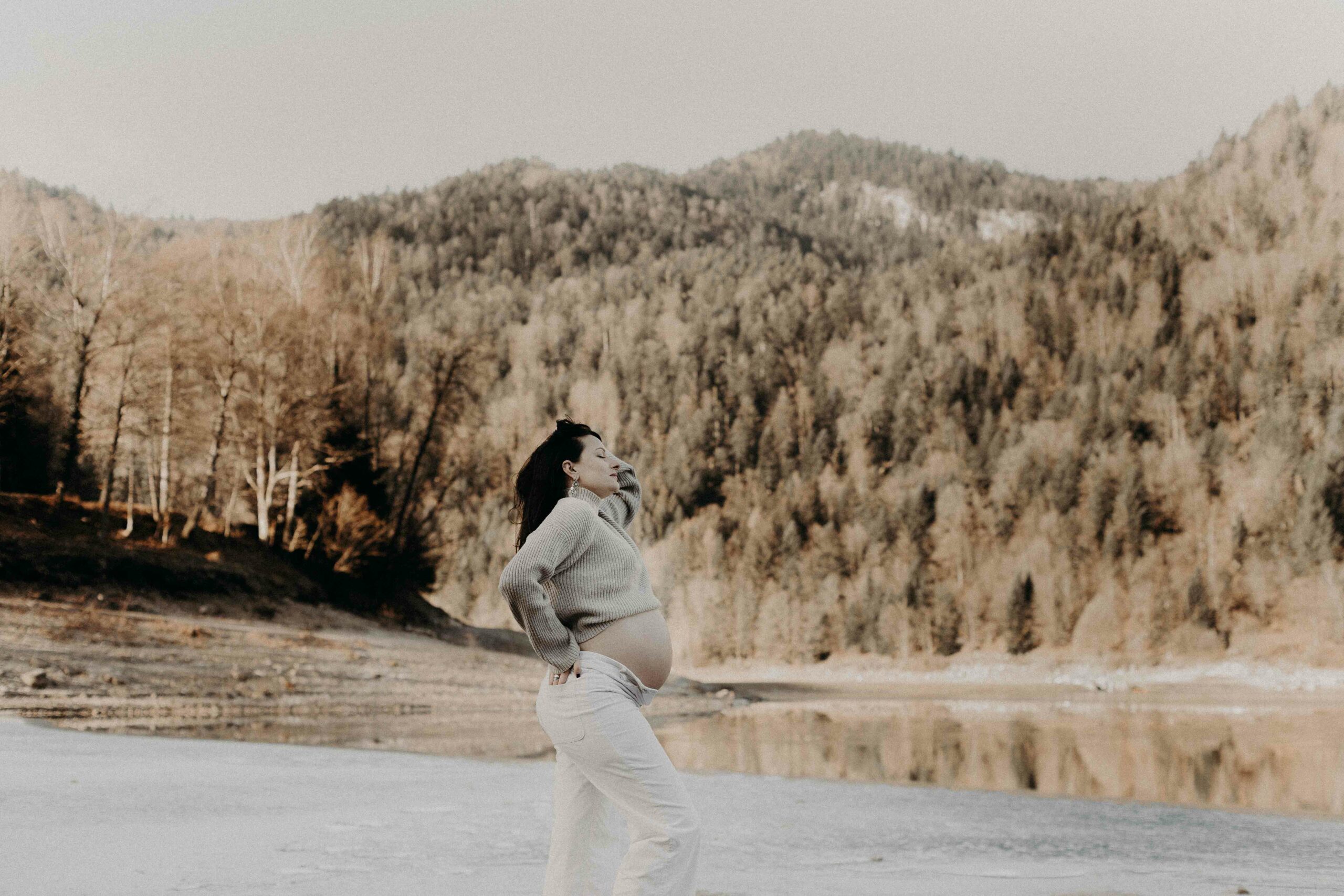 silhouette d'un ventre de femme enceinte au bord de la mer au coucher du soleil