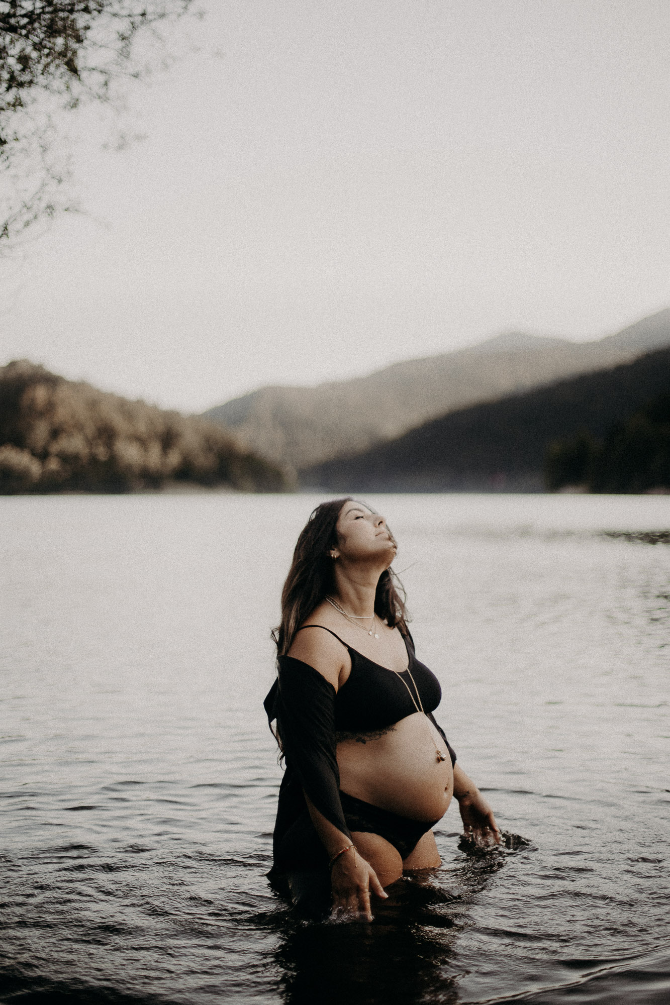 couple et femme enceinte s'embrassent dans la mer au coucher du soleil